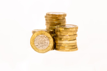 Stacks and Heaps of British GBP Golden Coins Currency Money on white background with empty space