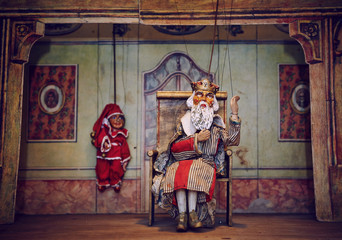 Handmade wooden puppet theater. King and Jester - clown. Selective focus