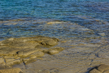 stones in vivid blue transparent sea water beach shore line south Mediterranean landscape