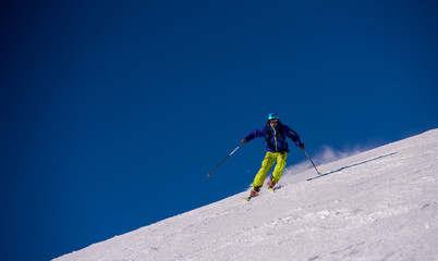 Naklejka na ściany i meble Skier having fun while running downhill