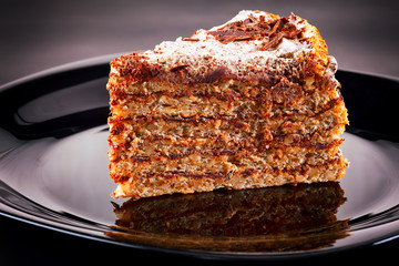 Piece of cake on black plate.