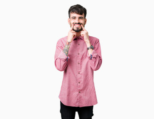 Young handsome man wearing pink shirt over isolated background Smiling with open mouth, fingers pointing and forcing cheerful smile