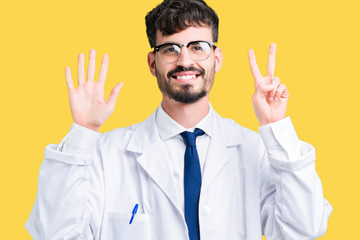 Young professional scientist man wearing white coat over isolated background showing and pointing up with fingers number seven while smiling confident and happy.