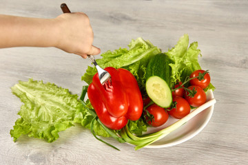 A child pins vegetables on a fork