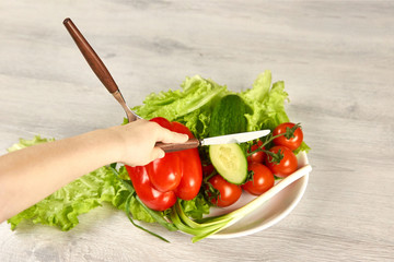 A child pins vegetables on a fork