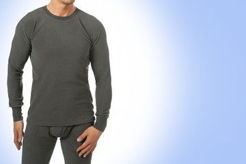 Man in thermal underwear for active winter sport. Man wearing Thermolinen isolated on blue background. T-shirt with long sleeves and leggings