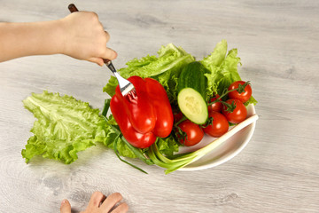 A child pins vegetables on a fork