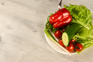 Vegetables in a white plate on a wooden background