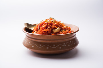 Gajar ka halwa is a carrot-based sweet dessert pudding from India. Garnished with Cashew/almond nuts. served in a bowl.