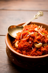 Gajar ka halwa is a carrot-based sweet dessert pudding from India. Garnished with Cashew/almond nuts. served in a bowl.