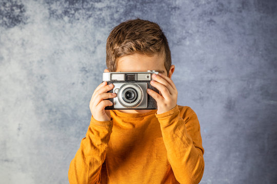 Portrait of young boy with a photographic camera
