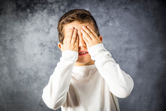 Portrait Of A Little Boy Covering His Eyes