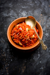 Gajar ka halwa is a carrot-based sweet dessert pudding from India. Garnished with Cashew/almond nuts. served in a bowl. - obrazy, fototapety, plakaty