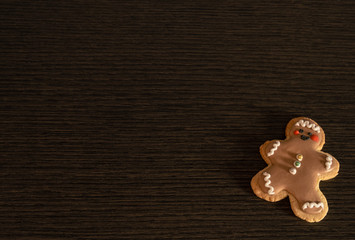 Traditional christmas cookie with shape of a funny man on wooden table. Homemade biscuit with copy space.