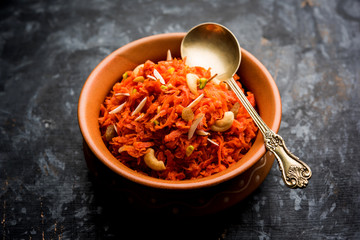 Gajar ka halwa is a carrot-based sweet dessert pudding from India. Garnished with Cashew/almond nuts. served in a bowl.