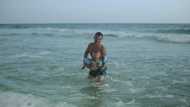 Young father and his little son have fun in the ocean 4k