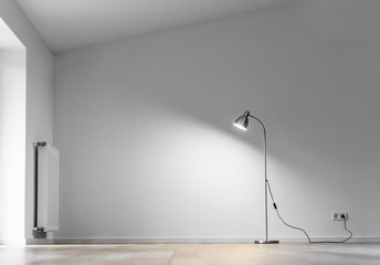 Fototapeta na wymiar metal floor lamp in empty room with shadow on white wall and copy space for text