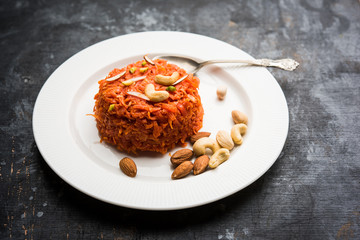 Gajar ka halwa is a carrot-based sweet dessert pudding from India. Garnished with Cashew/almond nuts. served in a bowl.