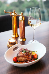 Baked juicy chicken breast and crispy skin with tomato and lemon served with white wine.