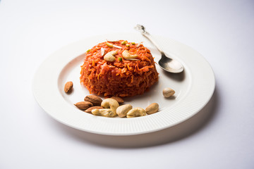 Gajar ka halwa is a carrot-based sweet dessert pudding from India. Garnished with Cashew/almond nuts. served in a bowl.