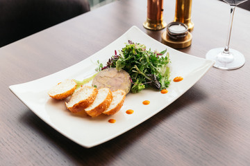 Canape with foie gras pate and salad served with white wine. © artitwpd