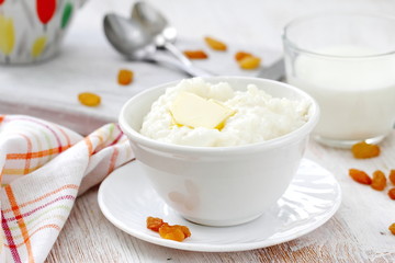 Sweet rice porridge with butter and mug of milk