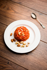 Gajar ka halwa is a carrot-based sweet dessert pudding from India. Garnished with Cashew/almond nuts. served in a bowl.