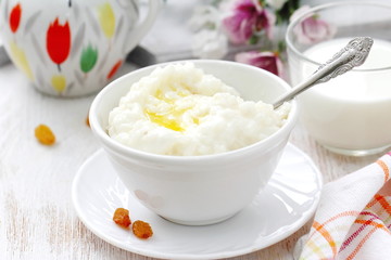 Sweet rice porridge with butter and mug of milk