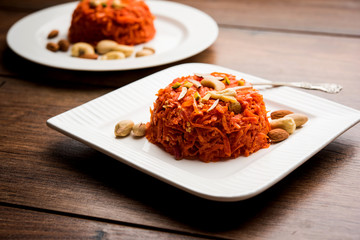 Gajar ka halwa is a carrot-based sweet dessert pudding from India. Garnished with Cashew/almond nuts. served in a bowl.