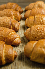Fresh baked croissants on a wooden stand.