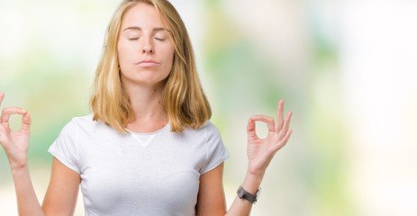 Beautiful young woman wearing casual white t-shirt over isolated background relax and smiling with eyes closed doing meditation gesture with fingers. Yoga concept.
