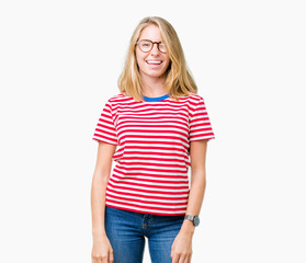 Beautiful young woman wearing glasses over isolated background winking looking at the camera with...
