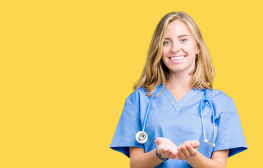 Beautiful young doctor woman wearing medical uniform over isolated background Smiling with hands palms together receiving or giving gesture. Hold and protection