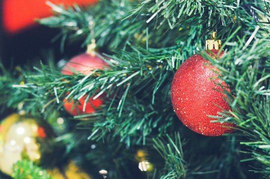 Christmas tree closeup. Red and gold balls macro photo. New Year holidays