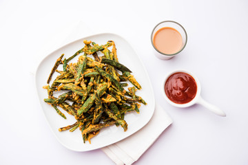Kurkuri bhindi or crispy ladyfinger or okra fry recipe, served in a bowl with ketchup and hot tea....