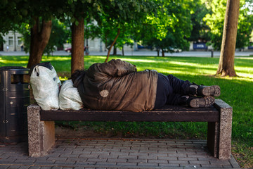 Homeless sleeping on a park bench. Lithuania