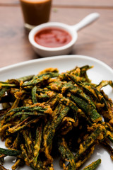Kurkuri bhindi or crispy ladyfinger or okra fry recipe, served in a bowl with ketchup and hot tea. selective focus