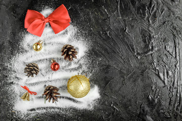 Christmas tree of snow with cones, balls and red bow on black background