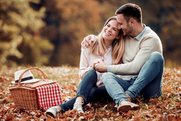 Couple in love sitting in autumn park