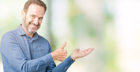 Handsome middle age elegant senior man over isolated background Showing palm hand and doing ok gesture with thumbs up, smiling happy and cheerful