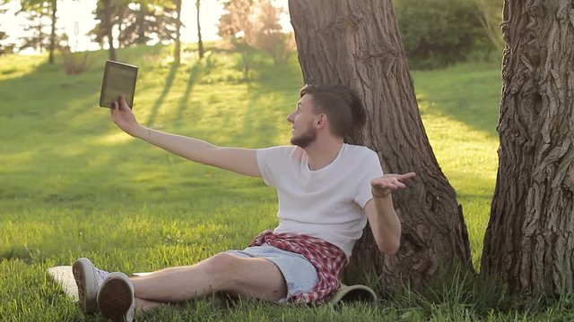 Young guy emotionally communicating with tablet pc