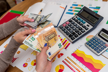 Fototapeta premium Female hands with dollar and euro exchanging with each other