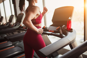 Crop sportswoman running on treadmill