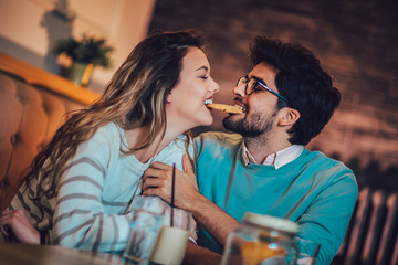  Beautiful loving couple sitting in a cafe drinking coffee and conversating. Love and romance concept.