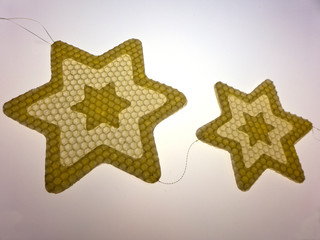 Sterne aus Bienenwachs vor weißem Hintergrund als Weihnachtsdekoration