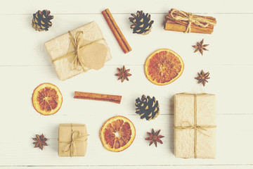 Fototapeta na wymiar Kraft paper gifts and spices on a white table. The original decor for Christmas. Beautiful layout, top view, flat lay.
