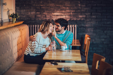 Beautiful loving couple sitting in a cafe drinking coffee and conversating. Love and romance concept.