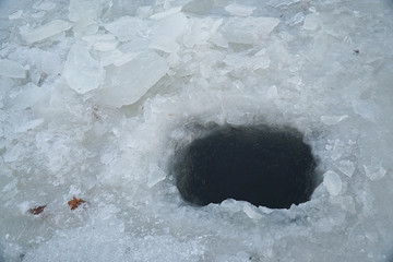 Ice hole in ice for winter fishing