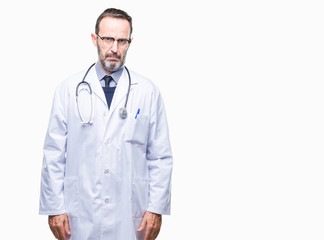 Middle age senior hoary doctor man wearing medical uniform isolated background skeptic and nervous,...
