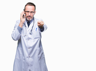 Middle age senior hoary doctor man talking on smartphone over isolated background pointing with finger to the camera and to you, hand sign, positive and confident gesture from the front